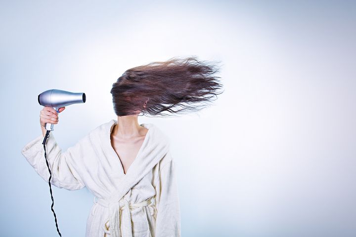 women drying hair by hair dryer