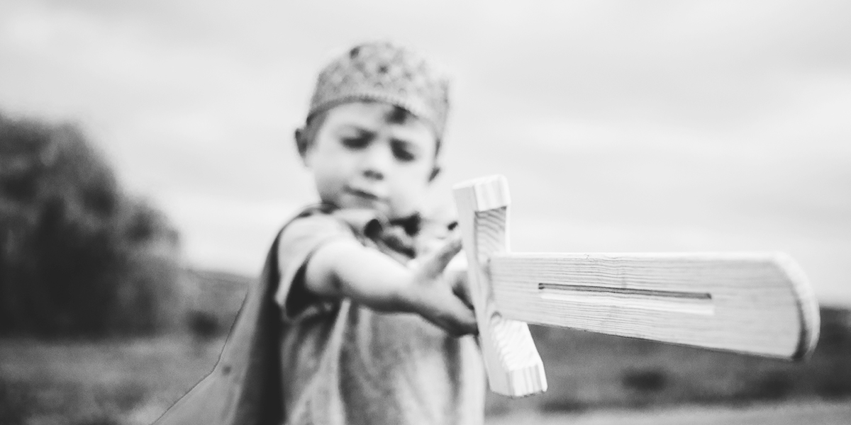 a small boy with a wooden sword