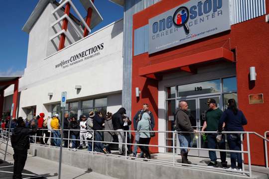 People wait in line for help with unemployment benefits