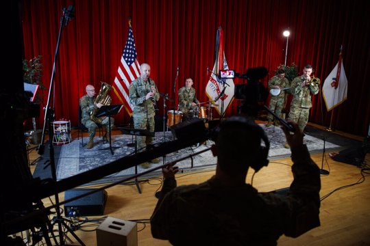 U.S. Army Field Band members from left, Chief Warrant Officer 2 Kevin Pick, on the tuba, Master Sgt. Bradford Danho, on the clarinet, Staff Sgt. Andrew Emerich, on the drums, Sgt. 1st Class Jonathan Epley, on the banjo and Staff Sgt. Kyle Johnson, on the trombone, are spaced to allow for social distancing as they play during the rehearsal of their daily "We Stand Ready" virtual concert series at Fort George G. Meade in Fort Meade, Md.