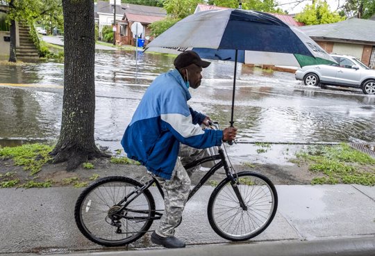 man riding bike with umbrella