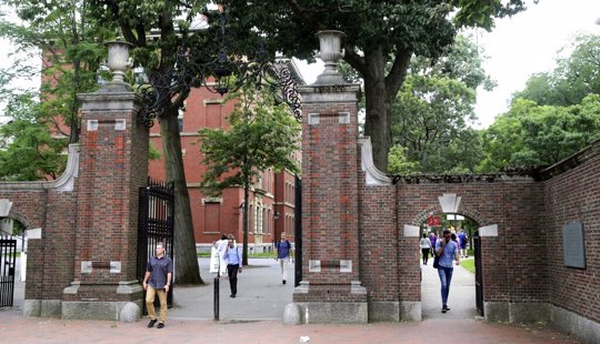 In this Aug. 13, 2019, file photo, pedestrians walk through the gates of Harvard Yard at Harvard University in Cambridge, Mass. Harvard and the Massachusetts Institute of Technology filed a federal lawsuit Wednesday, July 8, 2020, challenging the Trump administration's decision to bar international students from staying in the U.S. if they take classes entirely online this fall. Some institutions, including Harvard, have announced that all instruction will be offered remotely in the fall during the ongoing coronavirus pandemic.
