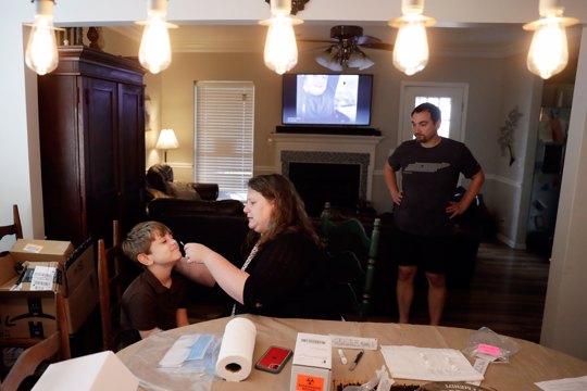 mom swabs the nose of her son for COVID-19 test