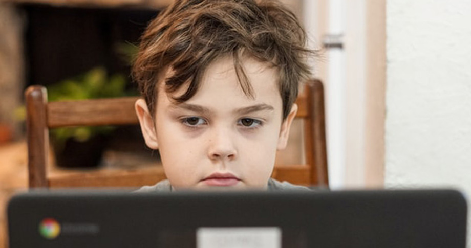 Boy stares blankly at computer screen