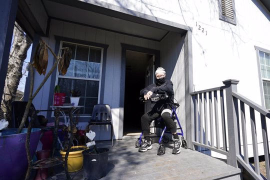 Nancy Wilson sits on her porch after returning from a water distribution in Houston. Wilson does not have full running water.