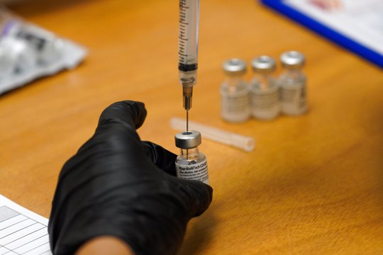 Health official draws from vile of COVID-19 vaccine prior to administering it