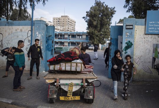 Palestinians flee their homes to a U.N. school after overnight Israeli heavy missile strikes on their neighborhoods in the outskirts of Gaza City