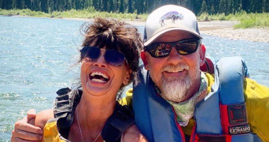 Man and wife with life jackets and sunglasses smiling