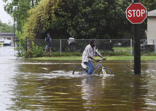 Man riding bike in flooded street