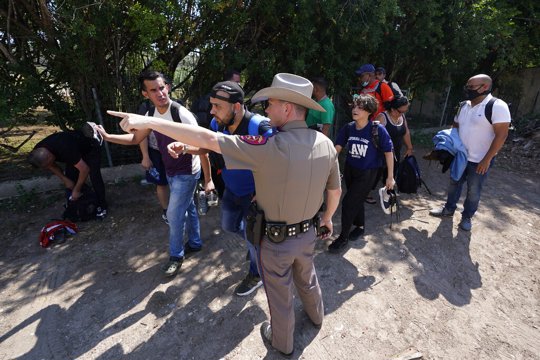 Texas Trooper and Migrants at Border