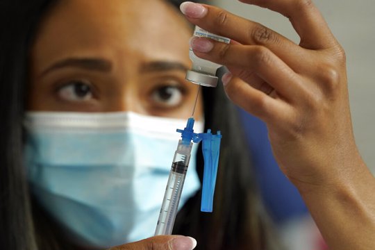 Nurse draws Moderna vaccine into a syringe