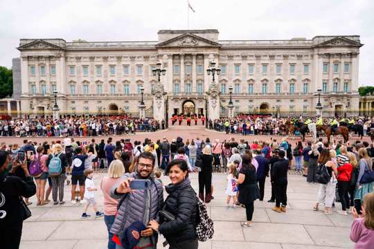 Members of the public watch the Changing of the Guard ceremony at Buckingham Palace, London, Aug. 23, 2021, which is taking place for the first time since the start of the coronavirus pandemic.