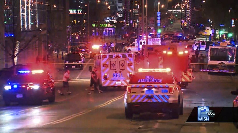 This photo taken from video provided by WISN 12 News shows police responding to the scene of a shooting at Water Street and Juneau Avenue in Milwaukee, Friday, May 13, 2022. Twenty people were injured in two shootings in downtown Milwaukee near an entertainment district where thousands of people were watching the Bucks play the Celtics in the NBA's Eastern Conference semifinals, authorities said. There was no immediate indication whether the two shootings were related or involved fans who were watching the game.