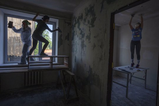 Women work to reconstruct a damaged fire department from Russian strikes, in Makariv, Kyiv region, Ukraine