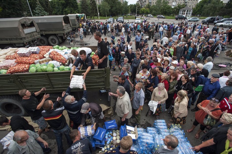 Local residents receive food stuff as humanitarian aid in a central square in Slovyansk, eastern Ukraine, Sunday, July 6, 2014. The eastern Ukrainian city of Slovyansk was occupied by pro-Russian separatists for months in 2014. Now its people are preparing to defend their community again as the fighting draws closer and invites a major battle. Slovyansk is a city of splintered loyalties, with some residents antagonistic toward Kyiv or nostalgic for their Soviet past.