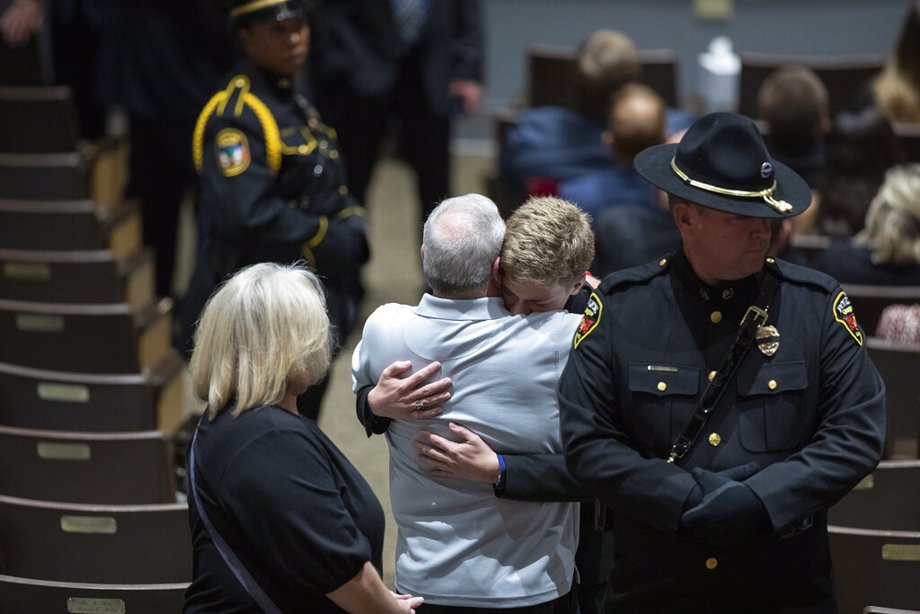 Family members embrace during the funeral for Floyd County Deputy William Petry at the Mountain Arts Center in Prestonsburg, Ky.