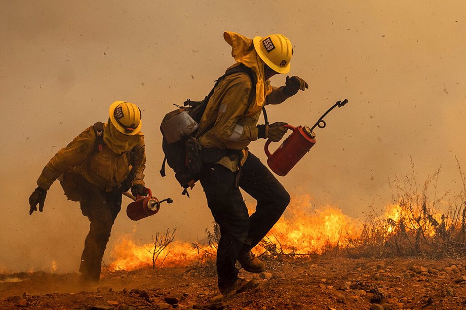 Firefighters burn vegetation while trying to keep the Electra Fire from reaching homes in the Pine Acres community of Amador County, Calif.