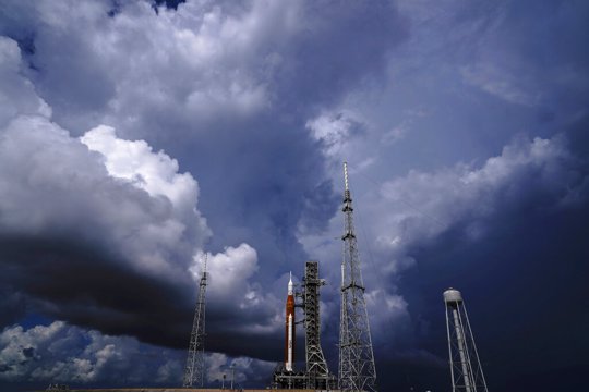 Moon rocket on launch pad with dark clouds overhead