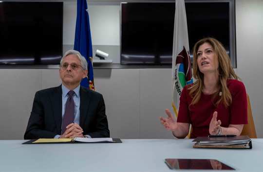 Attorney General Merrick Garland, left, listens as Drug Enforcement Administration Administrator Anne Milgram, right, speaks during in a press event to announce the results of an enforcement surge to reduce the fentanyl supply across the United States, at DEA headquarters, Arlington, Va., Tuesday, Sept. 27, 2022.