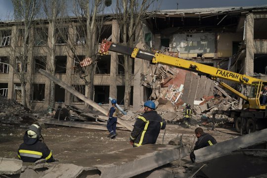 Rescue workers clear the debris after a Russian attack that heavily damaged a school in Mykolaivka, Ukraine