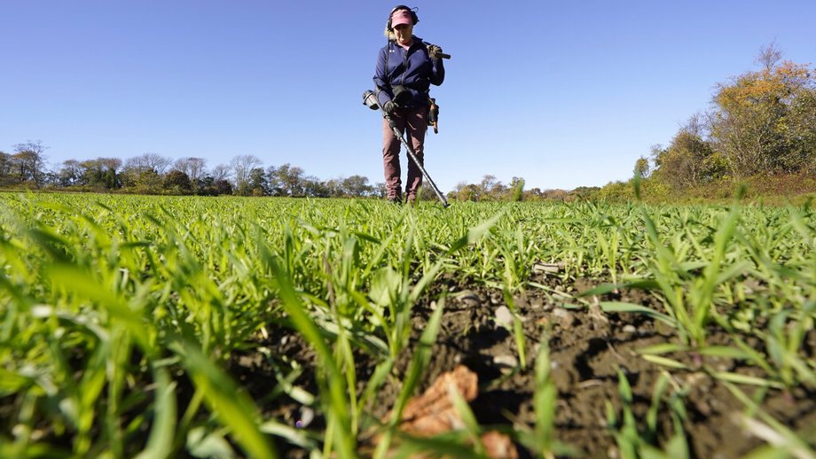 Metal detectorist Denise Schoener, of Hanson, Mass., searches for historic coins and artifacts in a farm field in Little Compton, R.I.