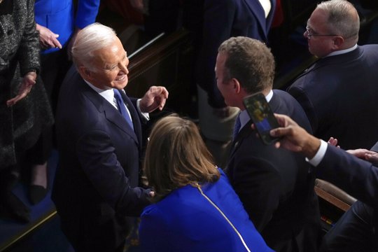 President Joe Biden greets people as he arrives in the House chamber to deliver the State of the Union address 