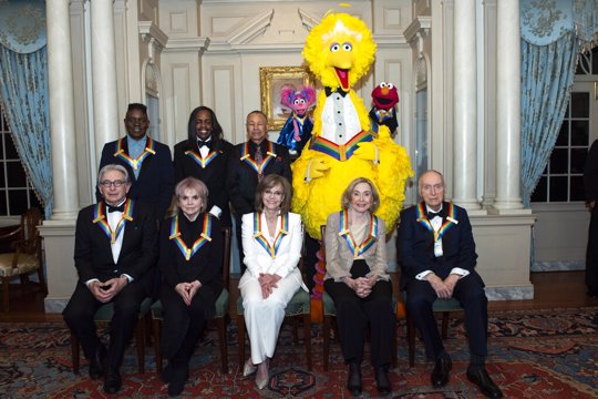Front row from left, 2019 Kennedy Center Honorees Michael Tilson Thomas, Linda Ronstadt, Sally Field, Joan Ganz Cooney, and Lloyd Morrisett, back row from left, Philip Bailey, Verdine White, Ralph Johnson, and characters from "Sesame Street," Abby Cadabby, Big Bird, and Elmo pose for a group photo following the Kennedy Center Honors State Department Dinner at the State Department on Saturday, Dec. 7, 2019, in Washington.