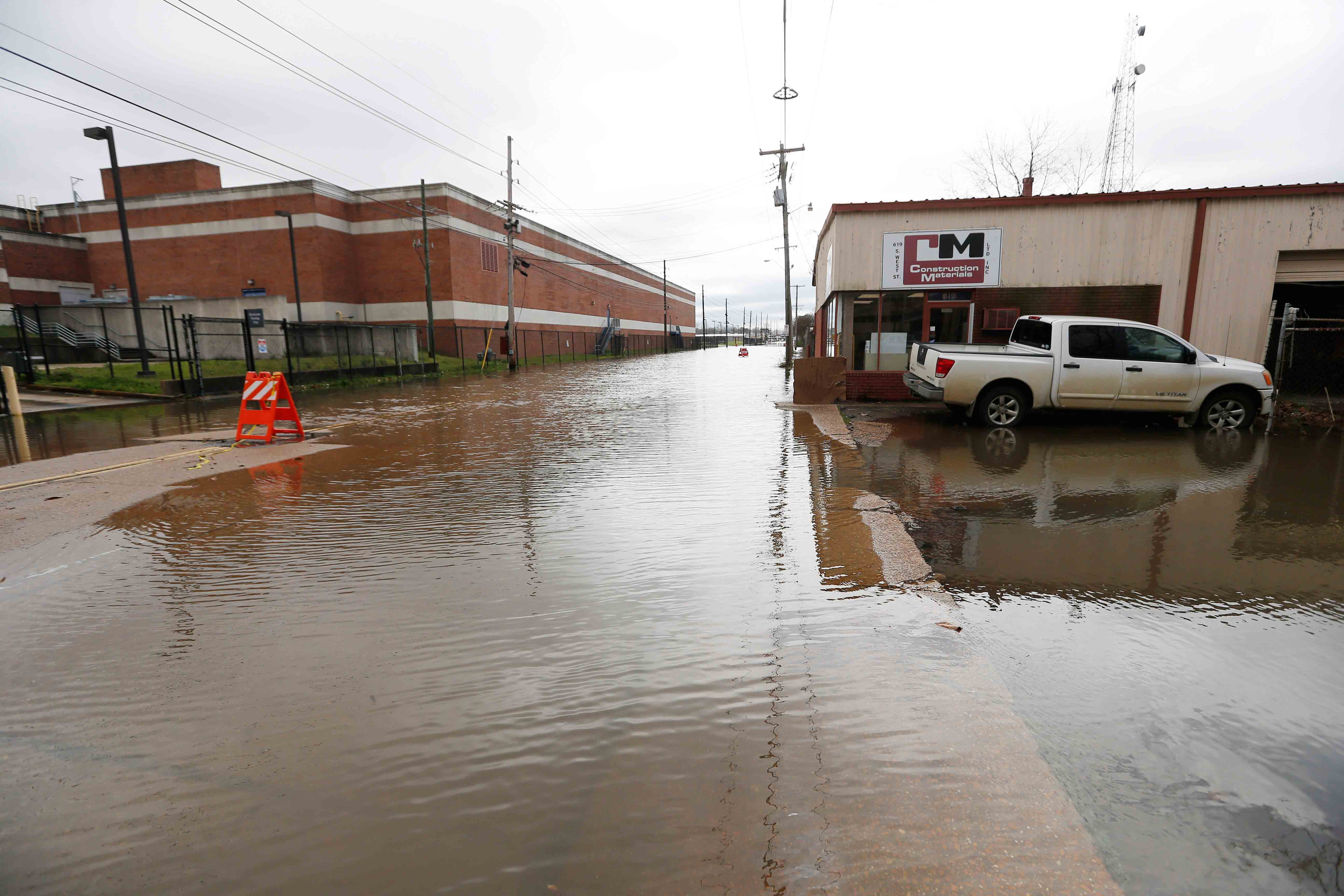 Floodwater from the Pearl River continues to flood downtown Jackson, Miss., including a construction business, right, and the main post office, left