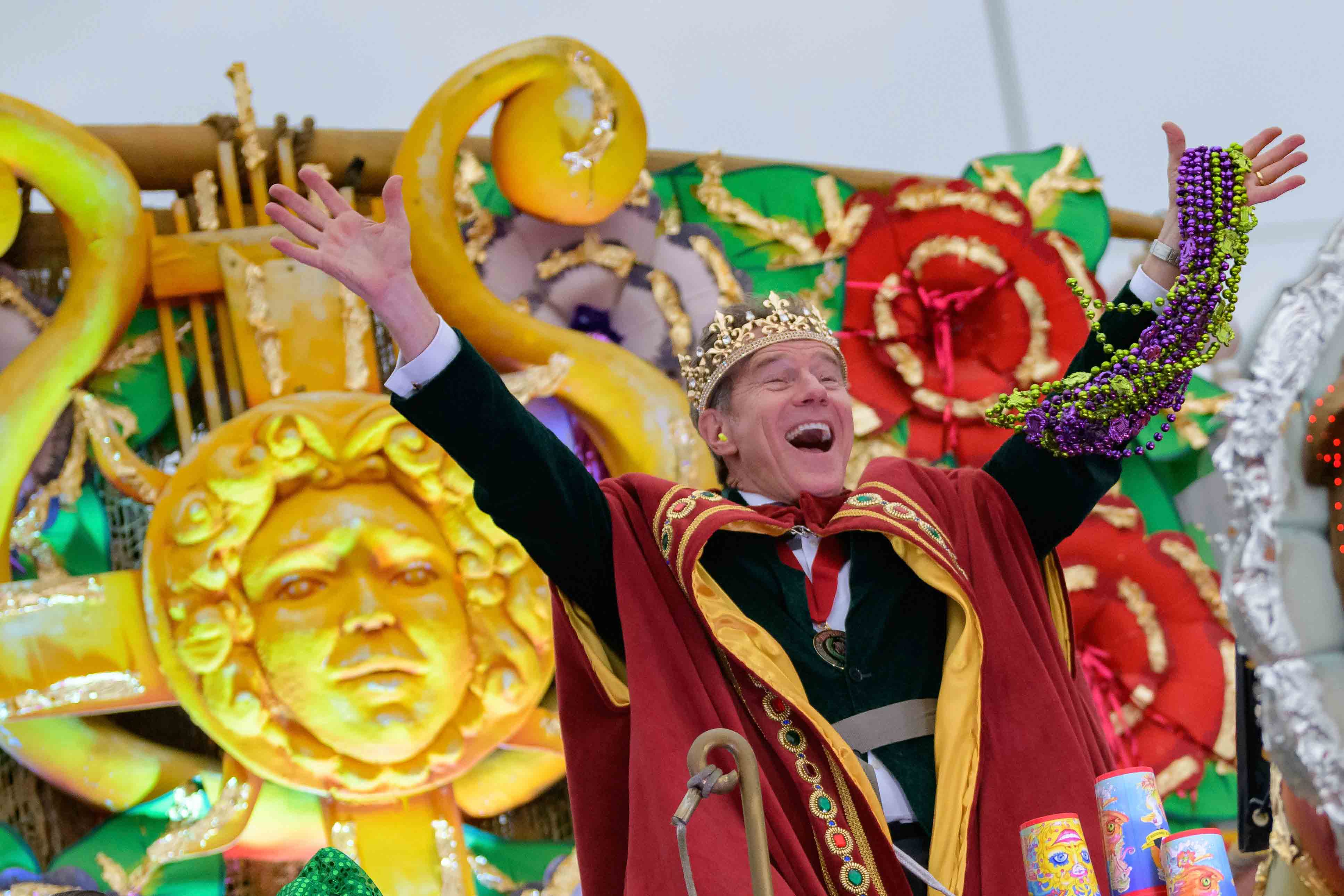 Actor Bryan Cranston waves beads as he acts as the celebrity monarch of the Krewe of Orpheus along the Uptown parade route during Mardi Gras celebrations in New Orleans