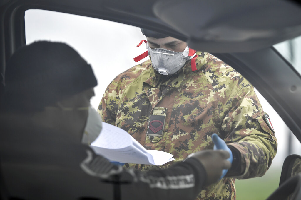 An Italian Army soldier checks transit to and from the cordoned areas near Turano Lodigiano, Northern Italy
