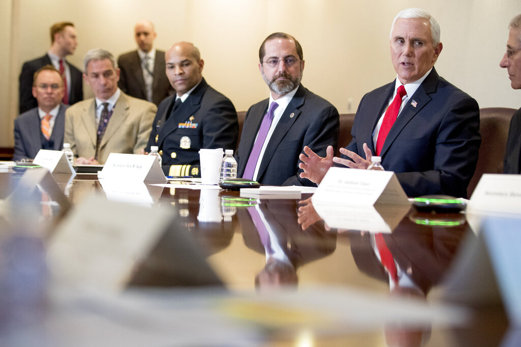 Vice President Mike Pence, third from left, accompanied by Surgeon General Jerome Adams, left, Health and Human Services Secretary Alex Azar, and others, speaks during a coronavirus task force meeting at the Department of Health and Human Services