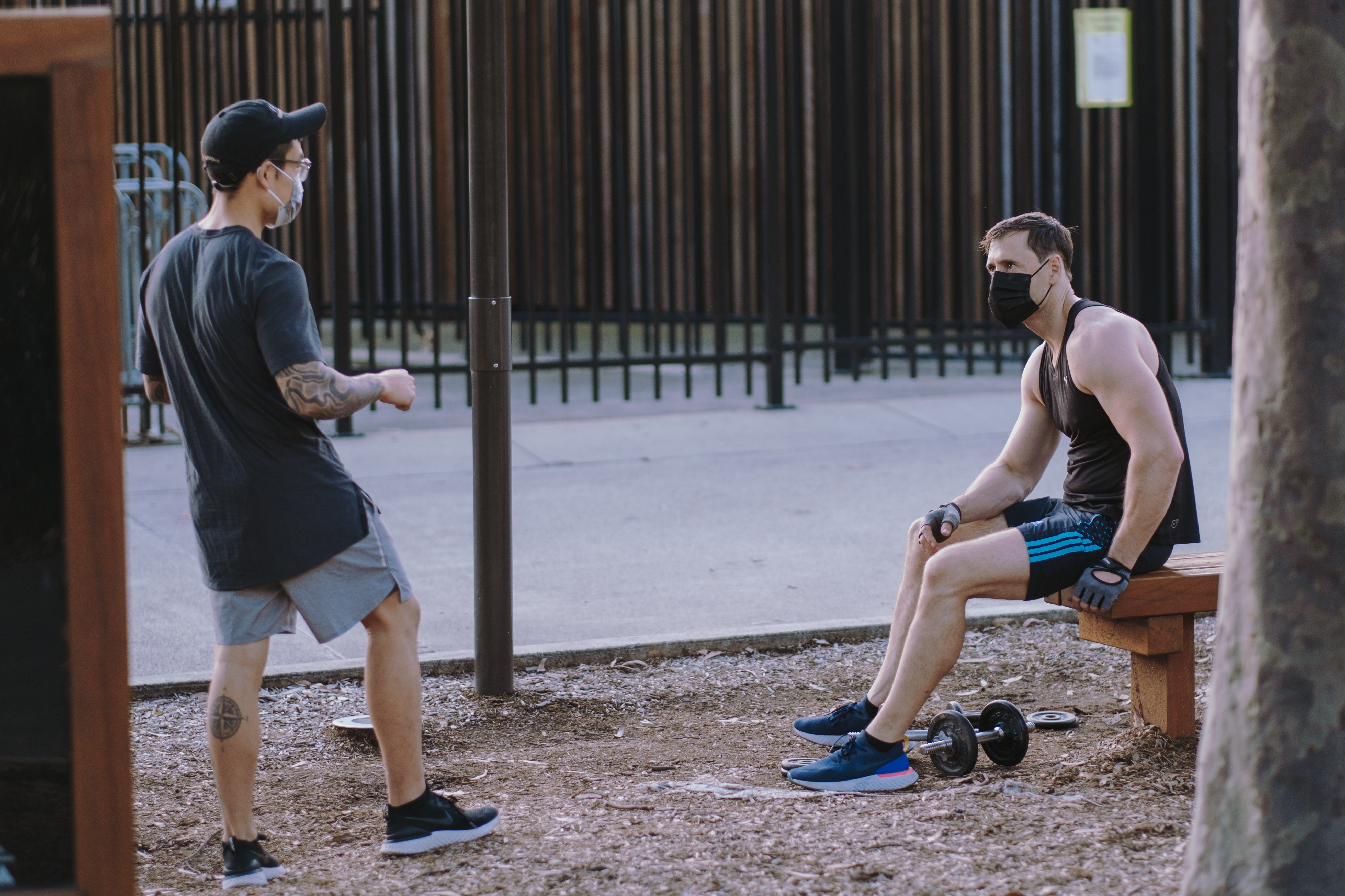 2 men, wearing face masks, talking 6ft apart