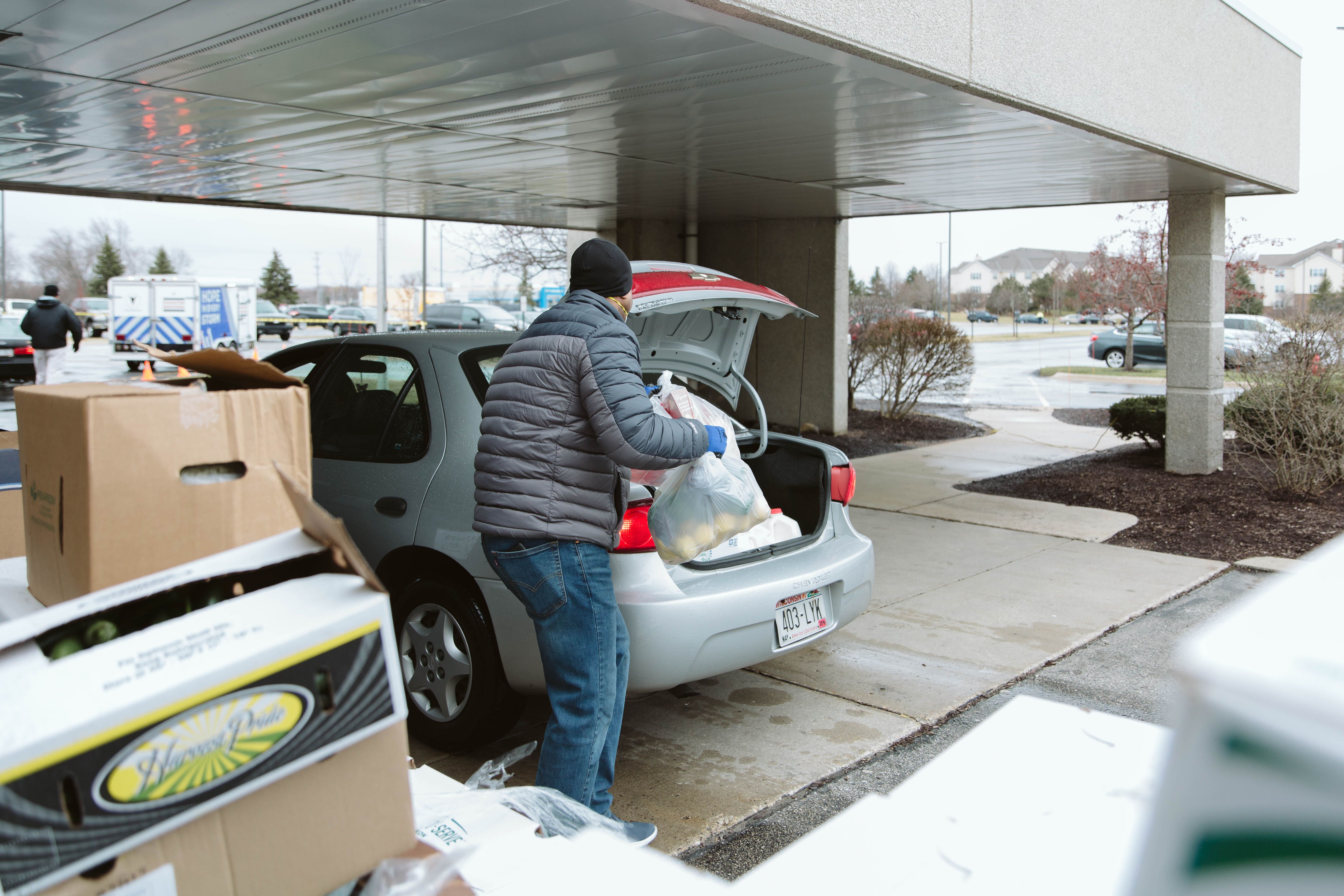 Man loads groceries into car trunk