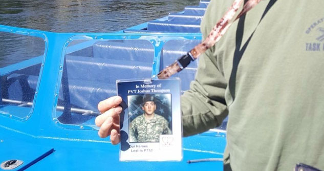 man holding a picture of a fallen service man