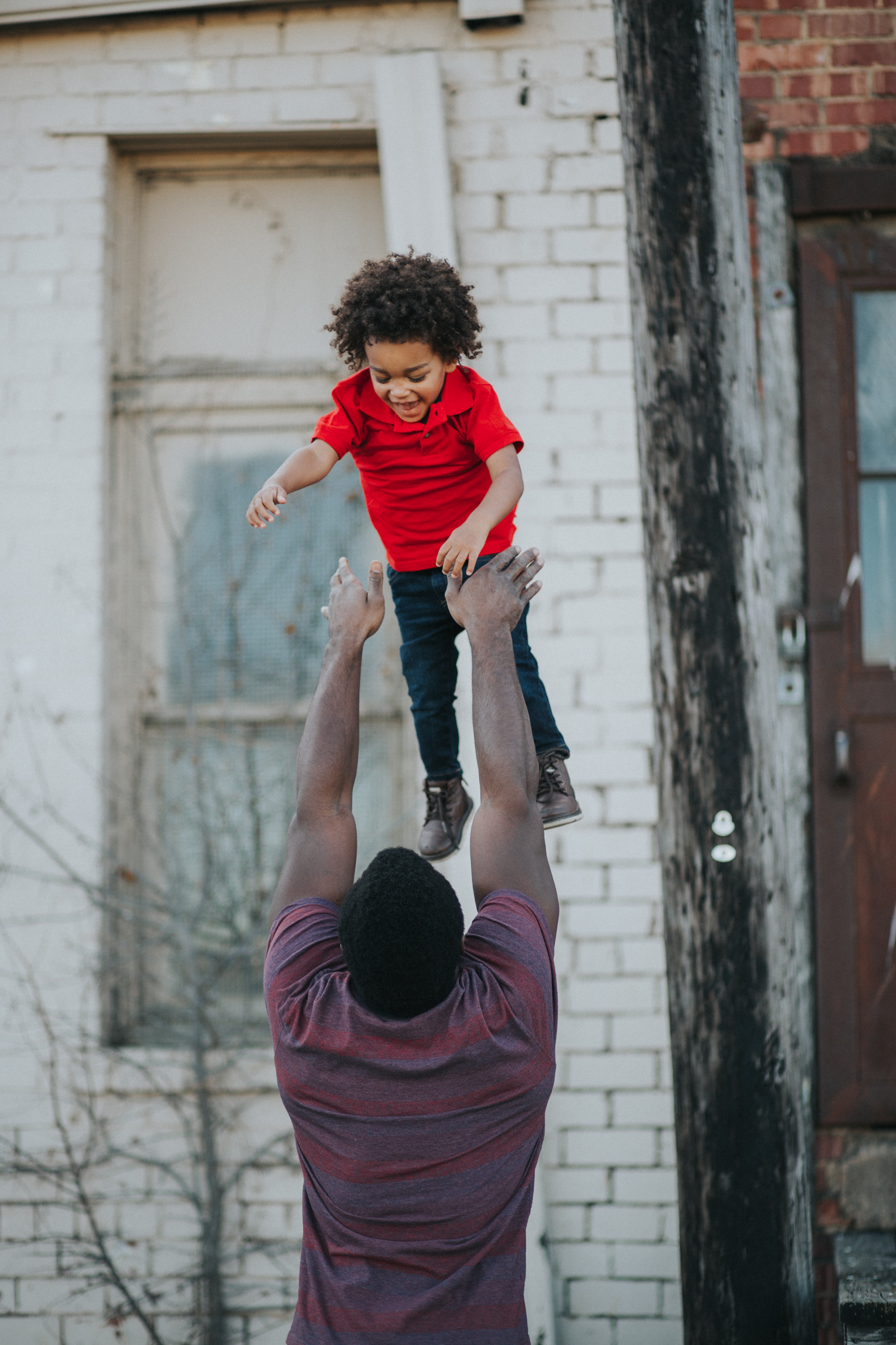 dad tosses his laughing child up in the air