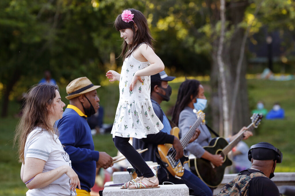 Young girl dances while listening to band in NYC park
