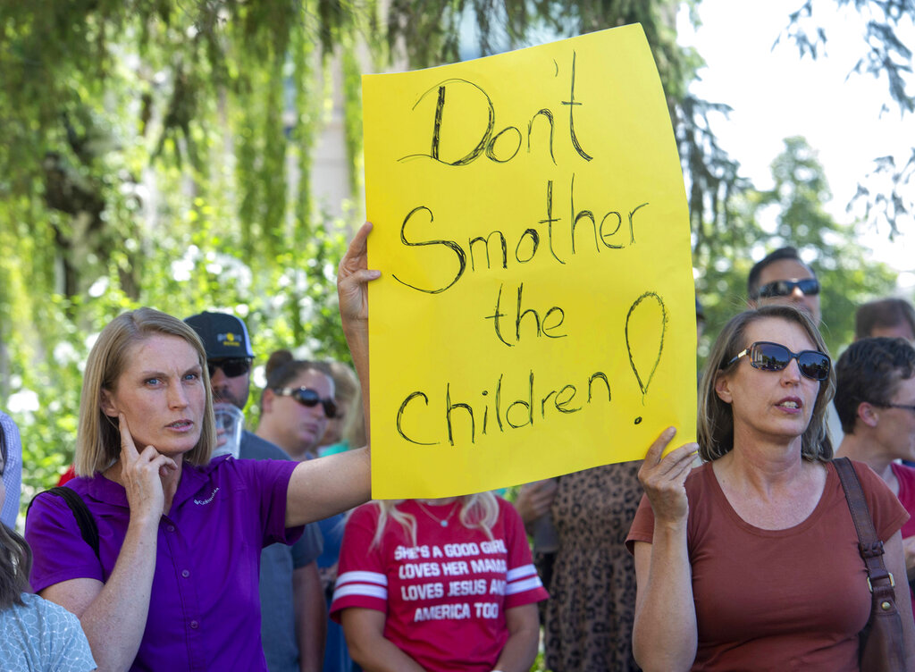 Protesters listen as commissioner Bill Lee speaks during a rally protesting against face masks being required in schools