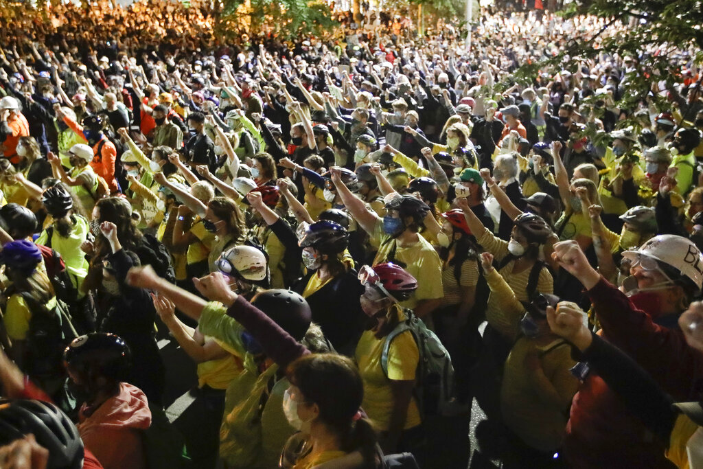 Demonstrators raise their fists during a Black Lives Matter protest at the Mark O. Hatfield United States Courthouse 