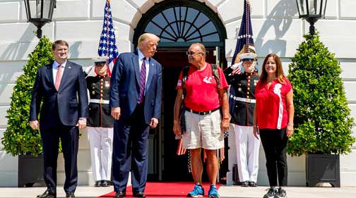 resident Donald Trump, Veterans Affairs Secretary Robert Wilkie, left, and Karen Pence, the wife of Vice President Mike Pence, right, pose for photographs with Terry Sharpe, third from right, known as the "Walking Marine" as he arrives at the White House