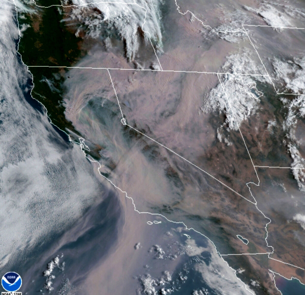 Satellite image from the Cooperative Institute for Research in the Atmosphere (CIRA) and released by the National Oceanic and Atmospheric Administration (NOAA) shows smoke from massive wildfires in Northern California, top left, being pushed by winds to the northeast