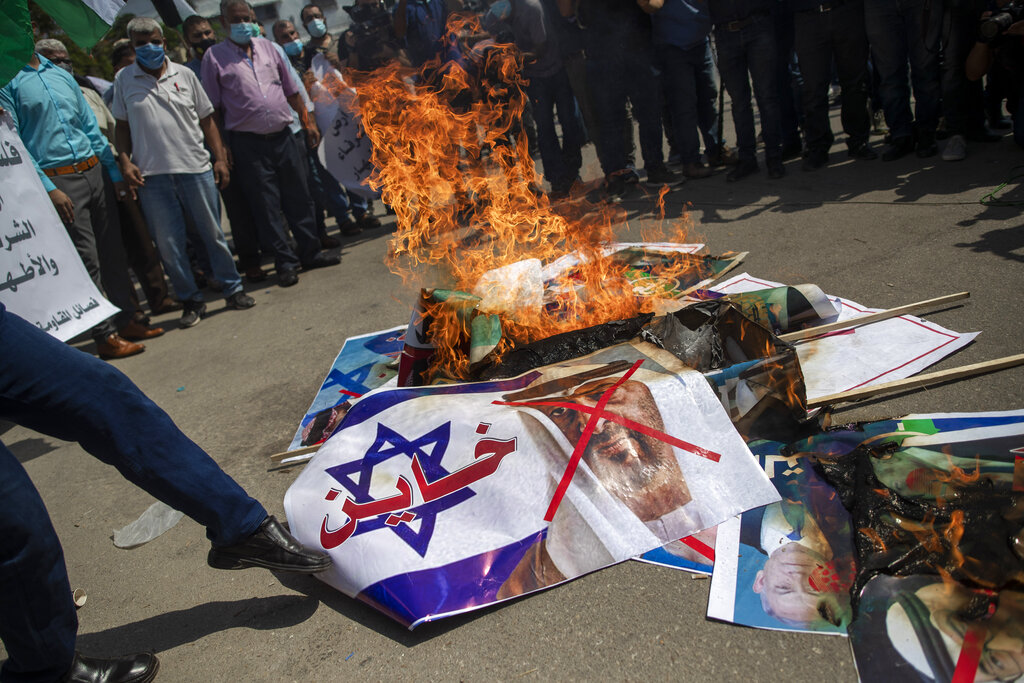 Palestinians burn pictures of U.S. President Donald Trump, Israeli Prime Minister Benjamin Netanyahu, Bahrain