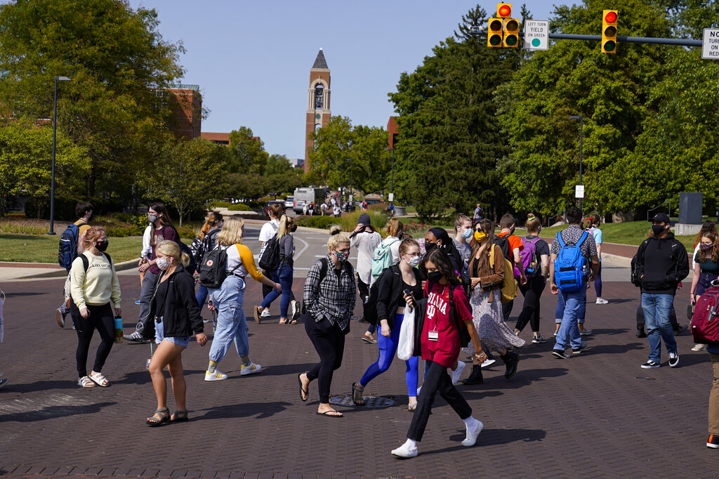 Masked students cross an intersection on the campus of Ball State University in Muncie, Ind.