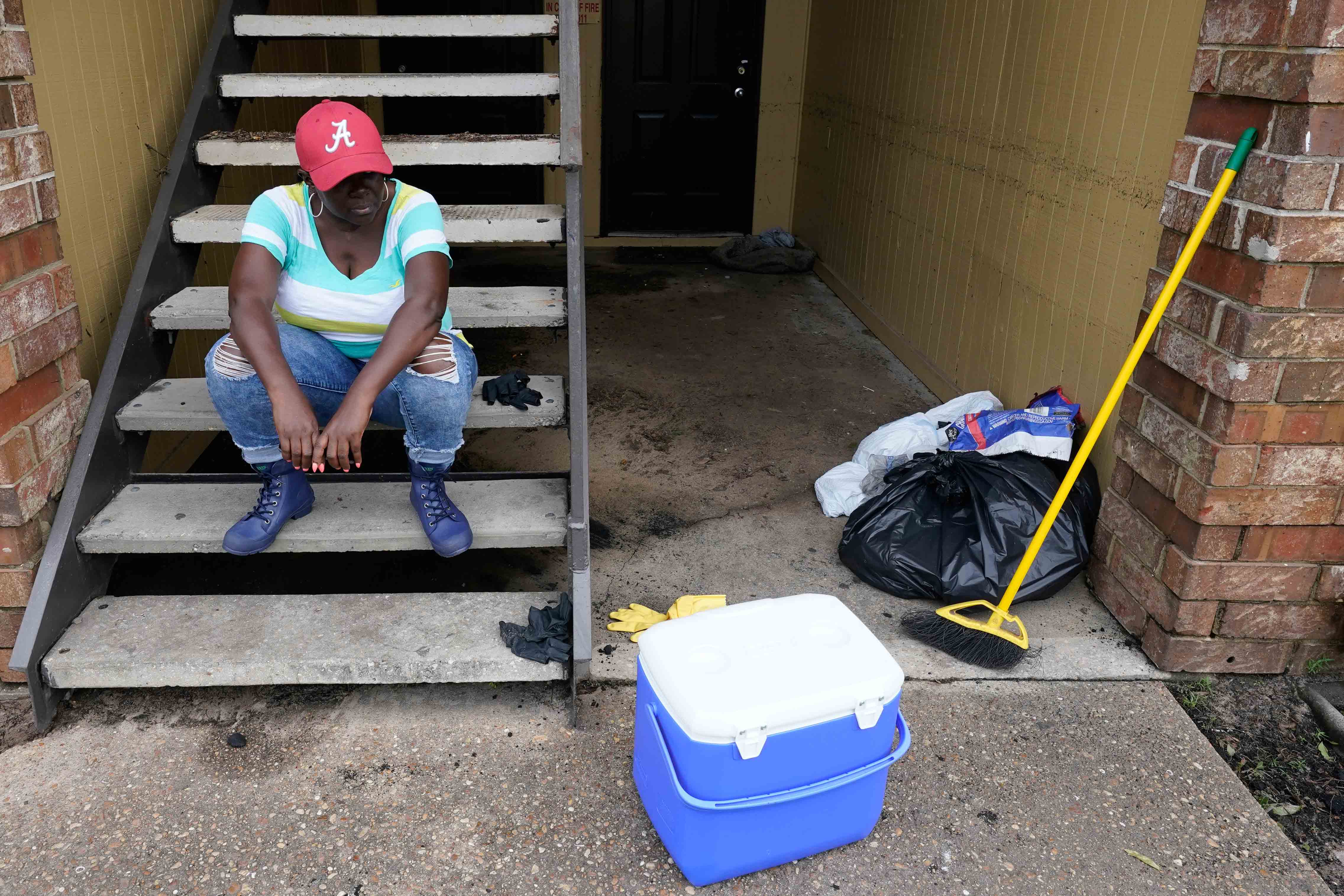 Person takes brake from cleaning up in aftermath of Hurricane Sally