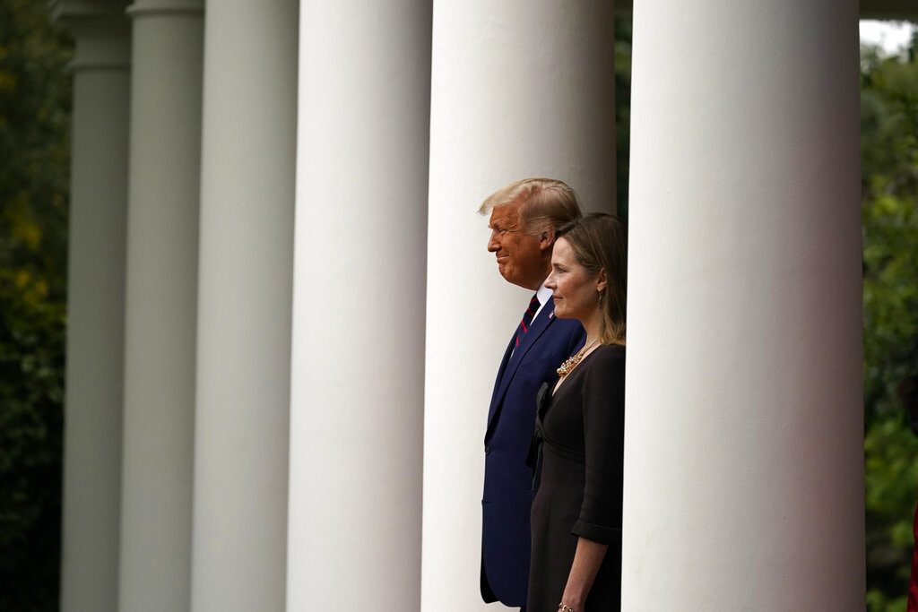 President Donald Trump walks with Judge Amy Coney Barrett to a news conference to announce Barrett as his nominee to the Supreme Court