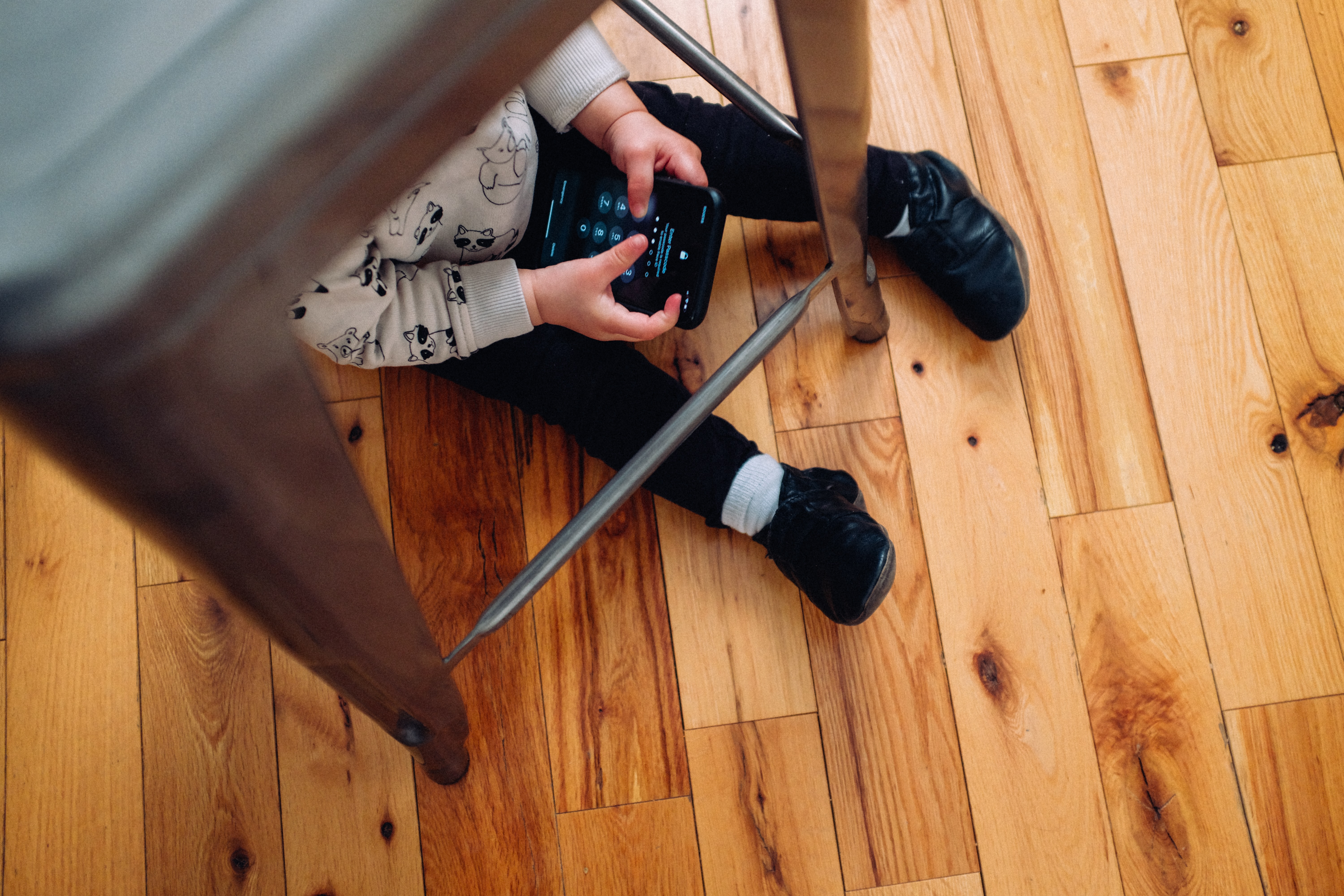 child on floor with phone