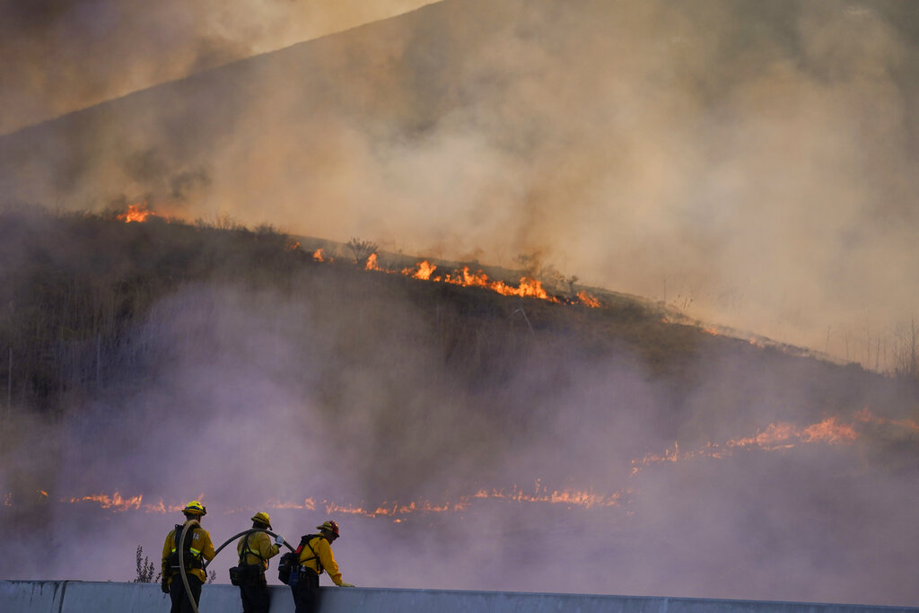 Firefighters watch as the Blue Ridge Fire burns along the 71 state highway 