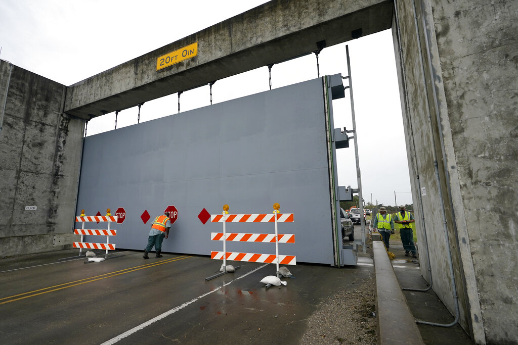 Workers close a floodwall gate on Hwy 39 in Poydras, La.
