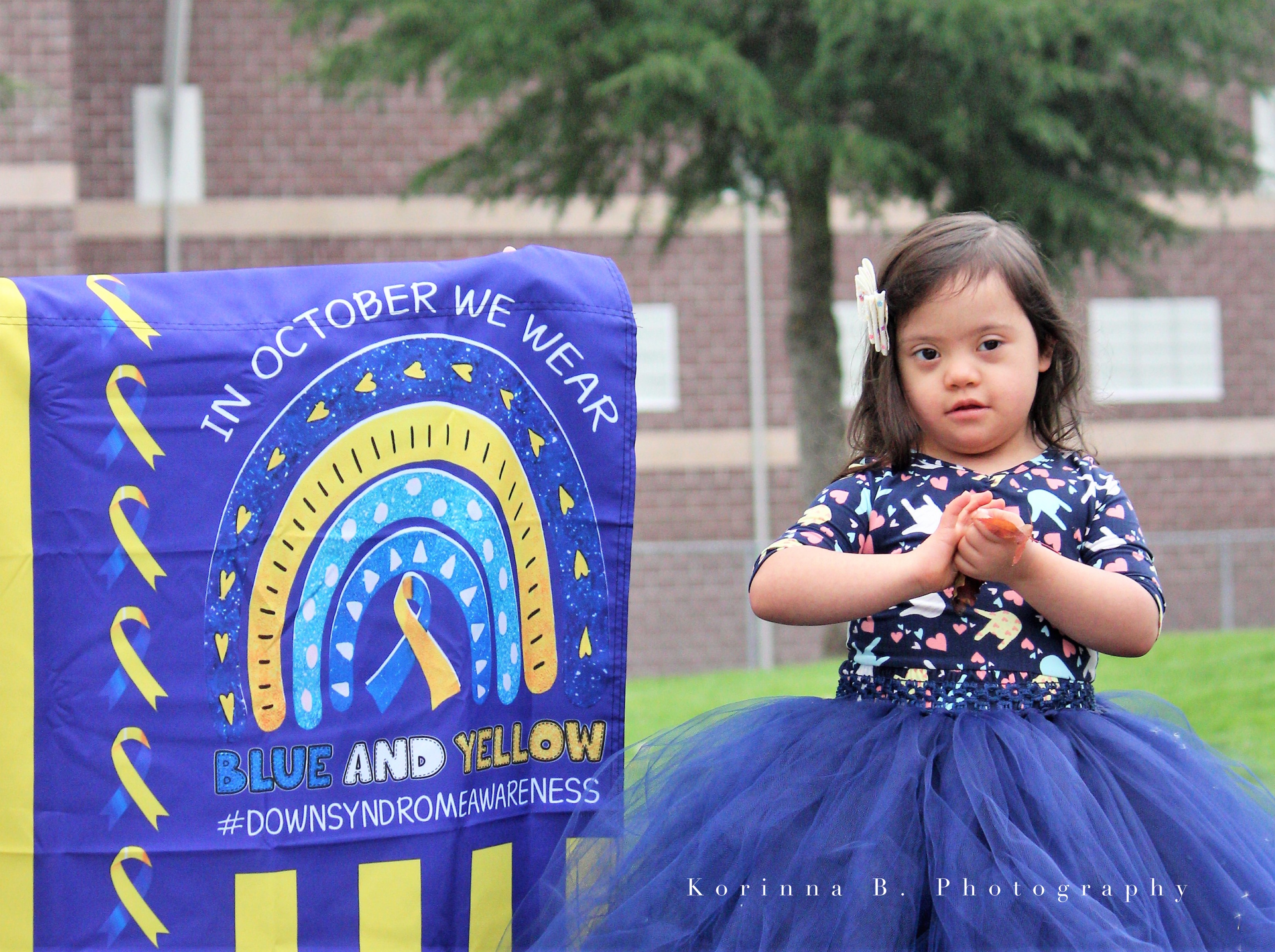 Arianna Graham standing in front of Blue and Yellow sign