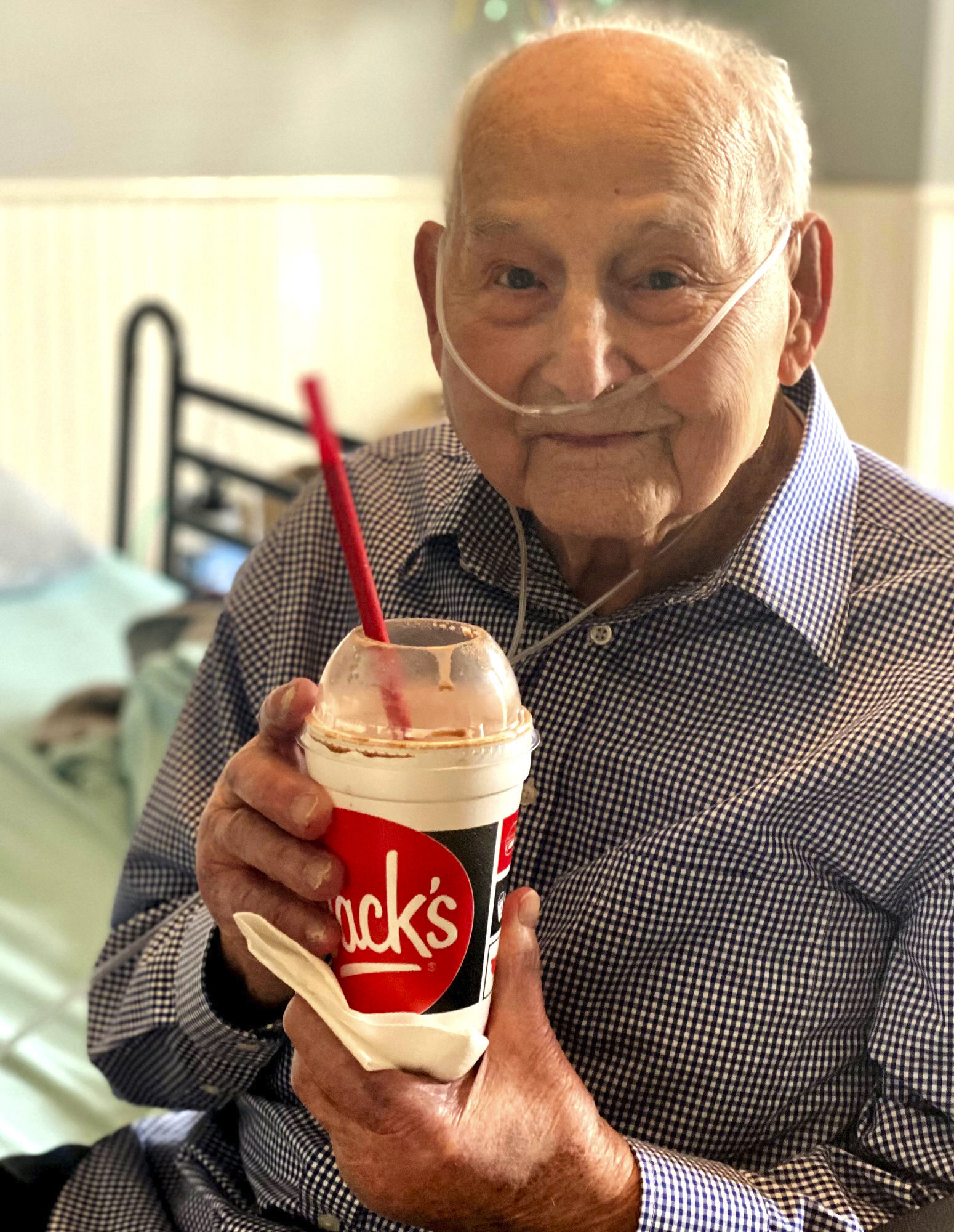 World War II veteran and COVID-19 survivor Major Wooten holds a celebratory milkshake on his 104th birthday