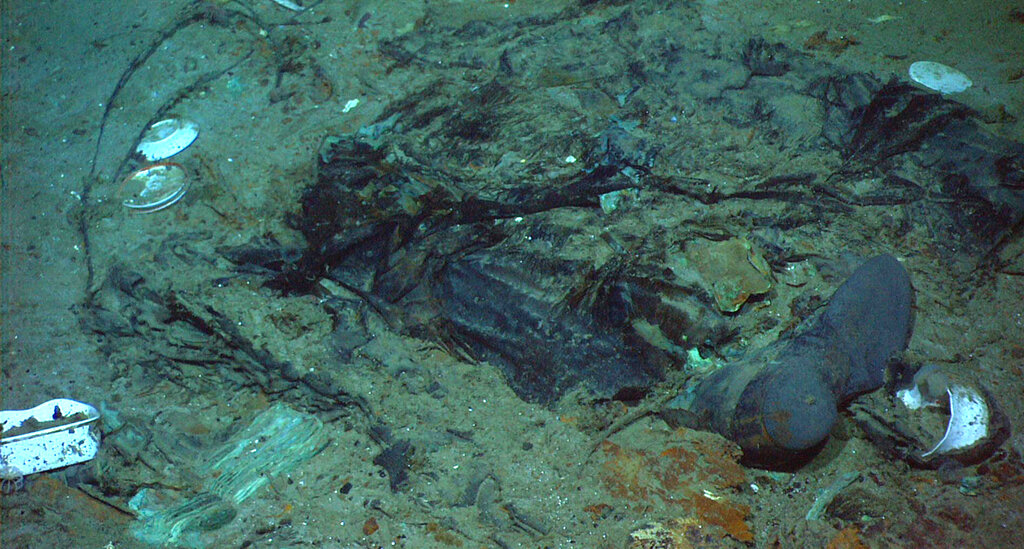 Remains of a coat and boots in the mud on the sea bed near the Titanic